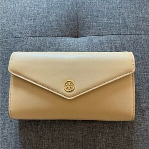 Tory Burch, cream colored clutch with cross-body strap.